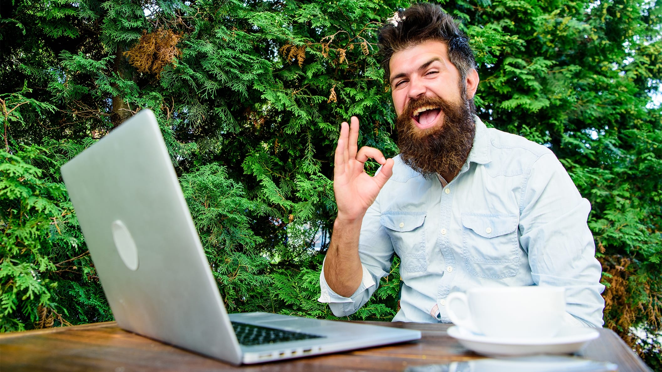 Tevreden klant werkt met laptop en maakt oké gebaar